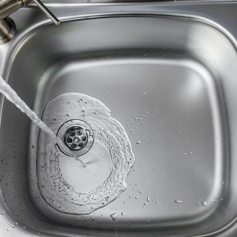 Wasser fließt in eine Küchenspüle