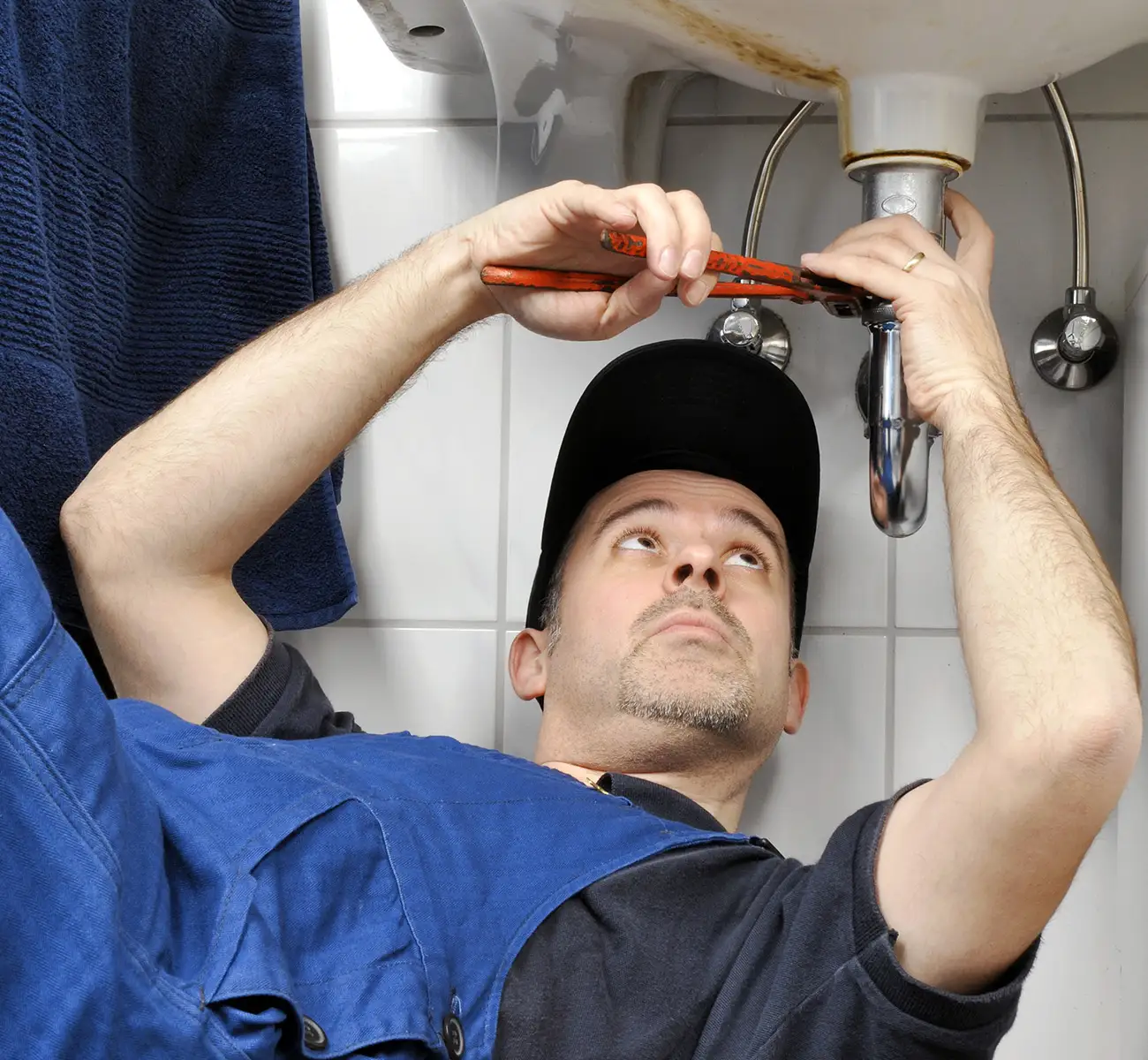 Klempner bei der Rohrreinigung unter Waschbecken