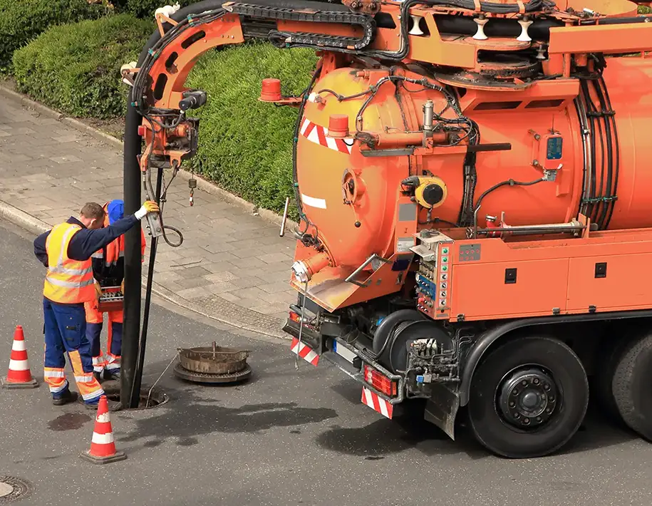 Mitarbeiter bei der Rohrortung an einem Kanal
