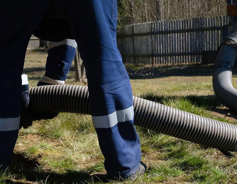 Mitarbeiter beim Reinigen eines Kanalrohrs mit Saugtechnik