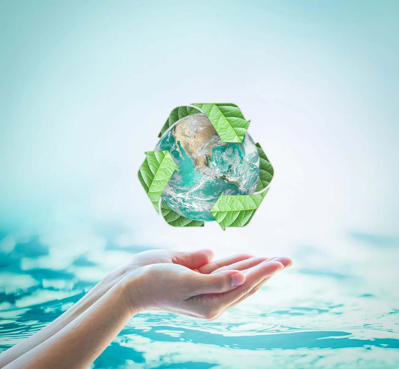 Hand mit Recyclingsymbol über blauem Wasser